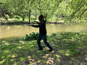 Teaching Team member, Charles Peters practices Single Whip beside a creek.